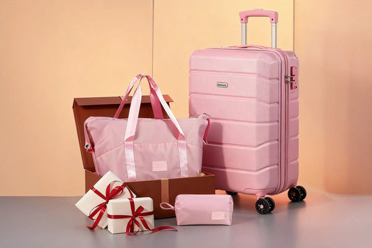 Pink Tavoxda suitcase with matching travel bag, pouch, and gift boxes on pastel background